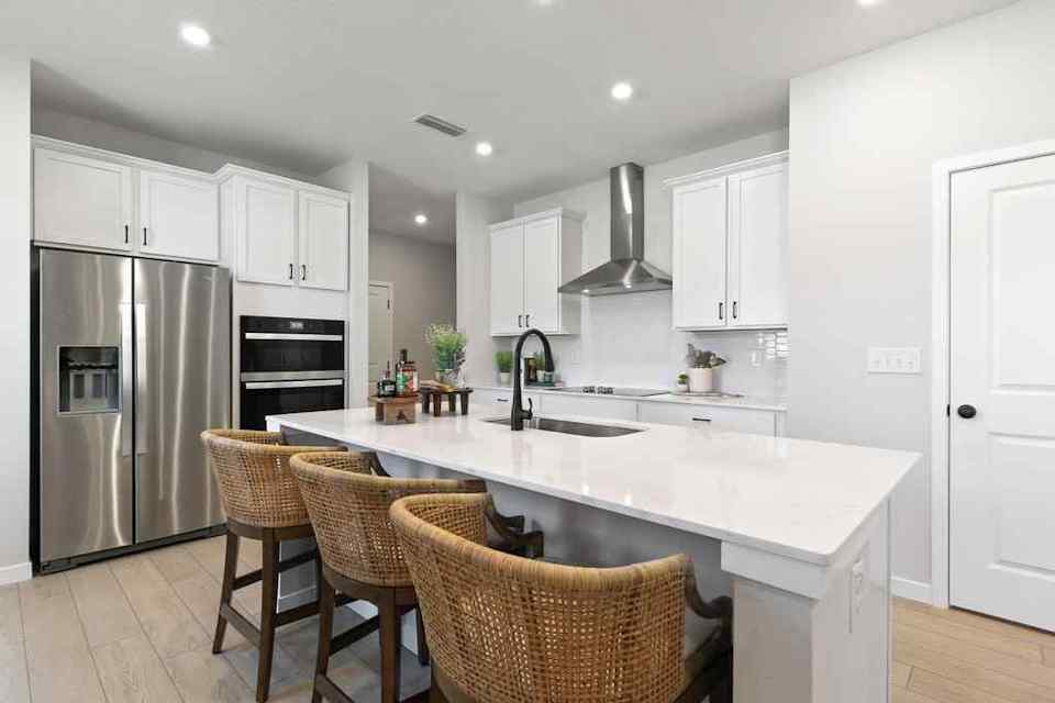 A kitchen with white cabinets.