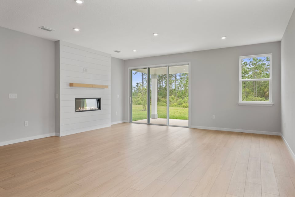 Charleston II Floorplan Lot 144 Great Room with Fireplace and Triple Slider Patio Doors at Seminole Palms in Palm Coast