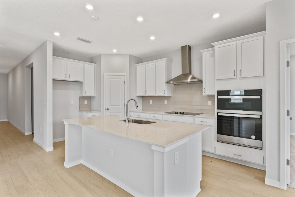 Palmetto Floorplan Lot 60 Chef's Kitchen with White Cabinets at Seminole Palms in Palm Coast