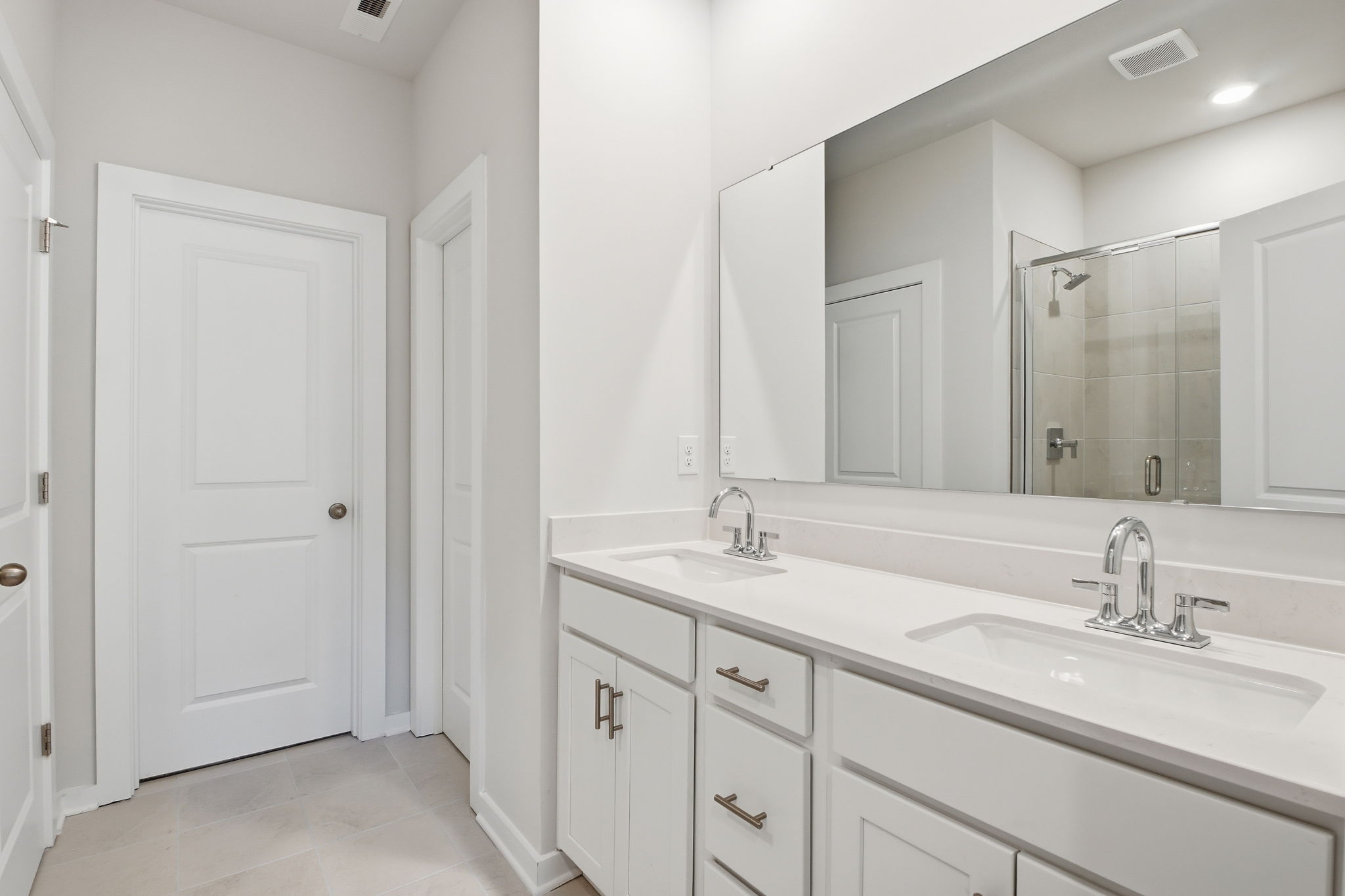 A bathroom with white cabinets.