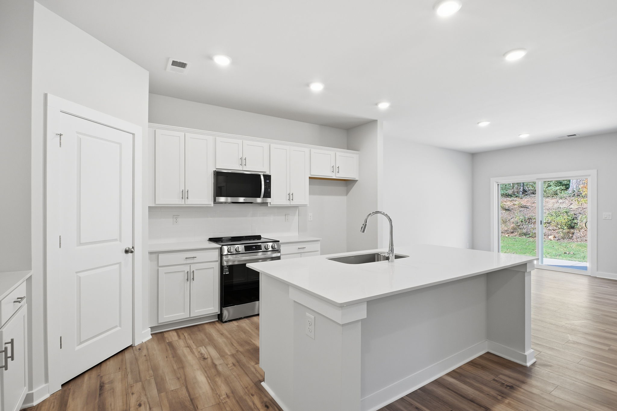 A kitchen with white cabinets.