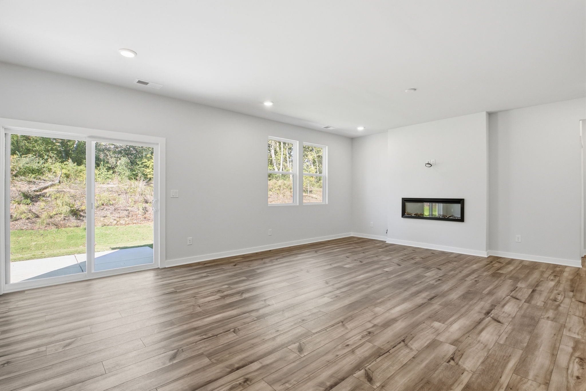 A room with a wood floor and windows.