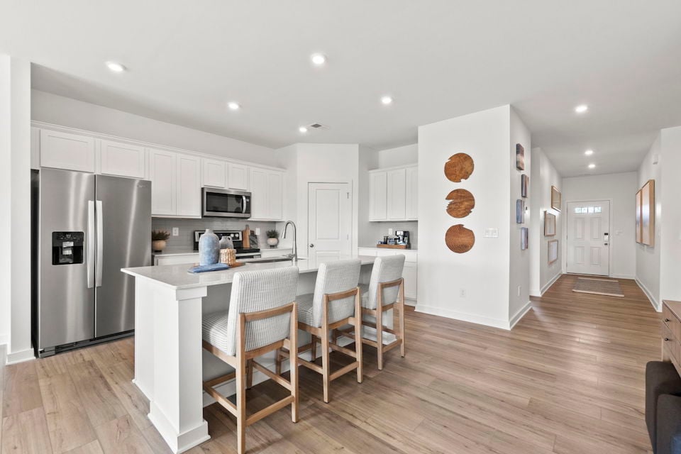 A kitchen with white cabinets.