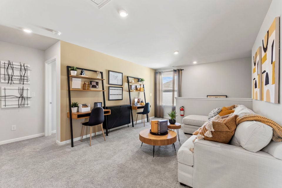 A living room with a desk and a chair.