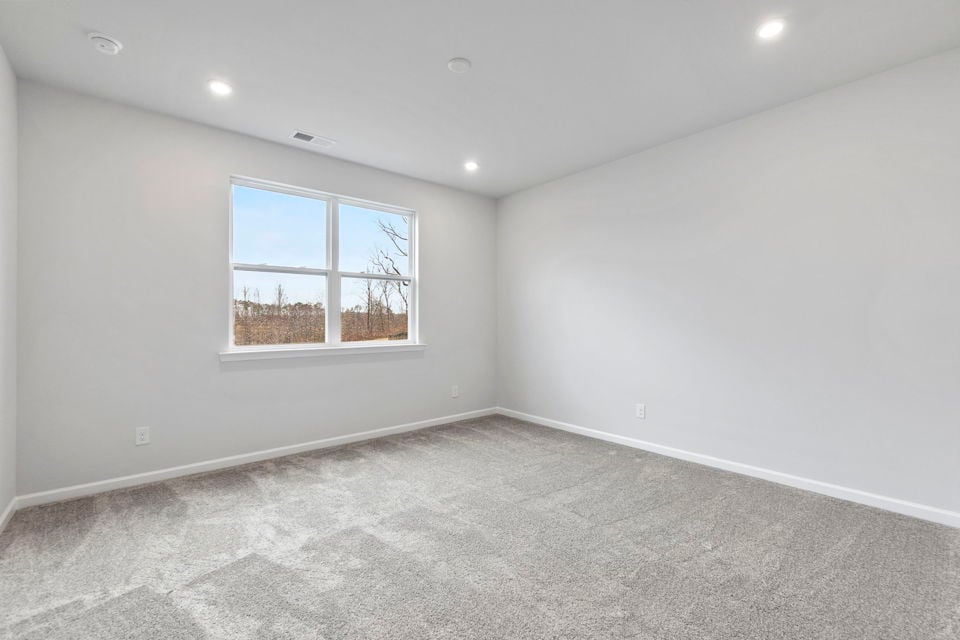 A room with a window and a carpet.