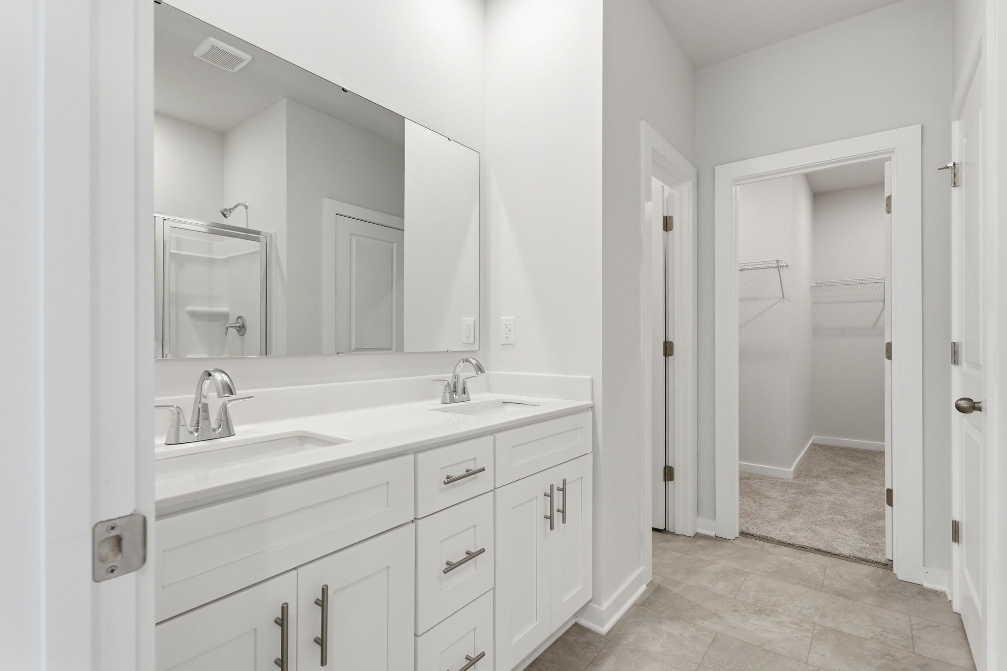 A bathroom with white cabinets.