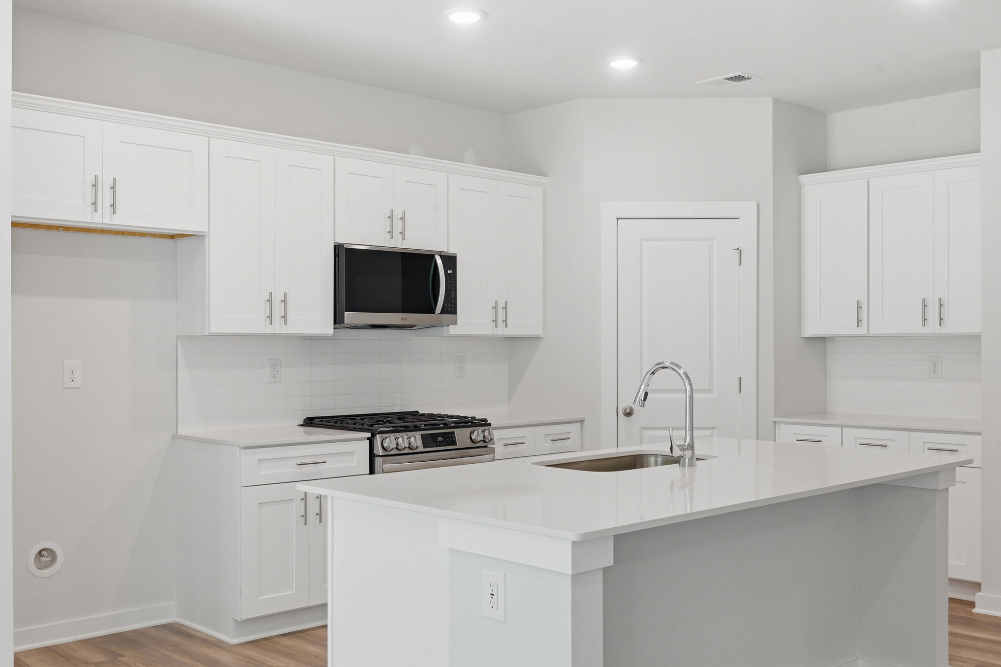 A kitchen with white cabinets.