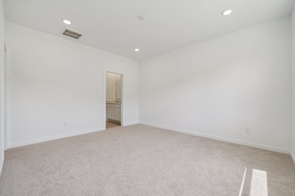 A room with a carpet and a door.
