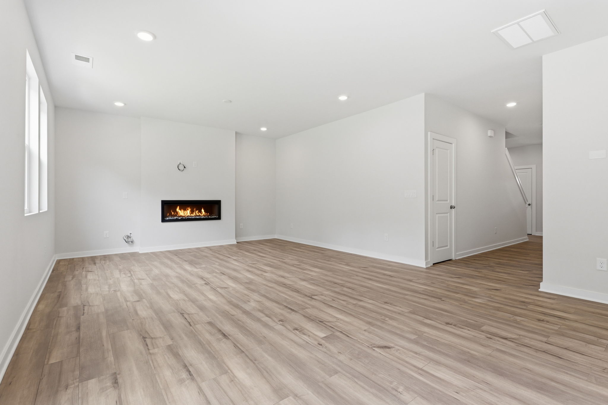 A room with a wood floor and a fireplace.