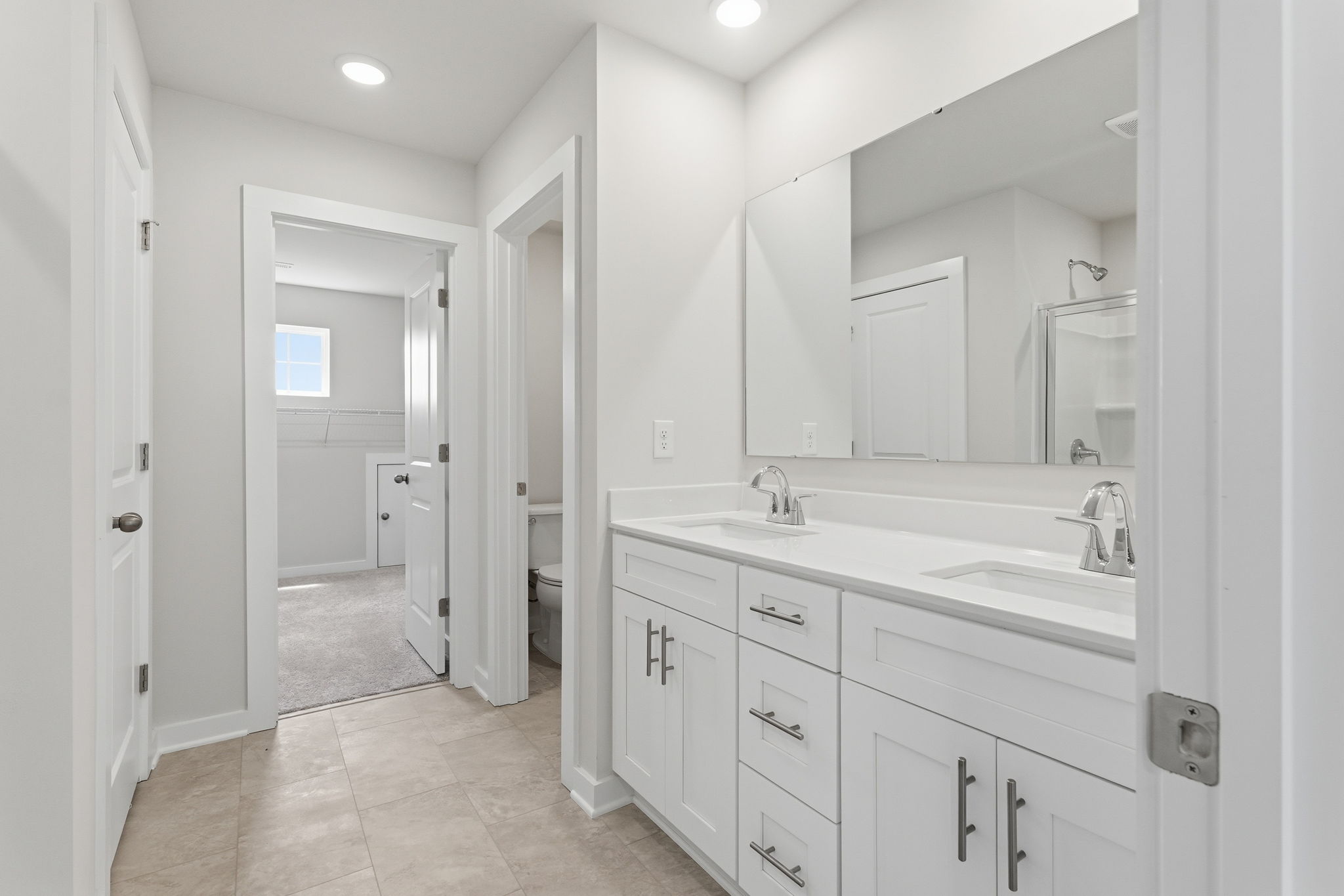 A bathroom with white cabinets.