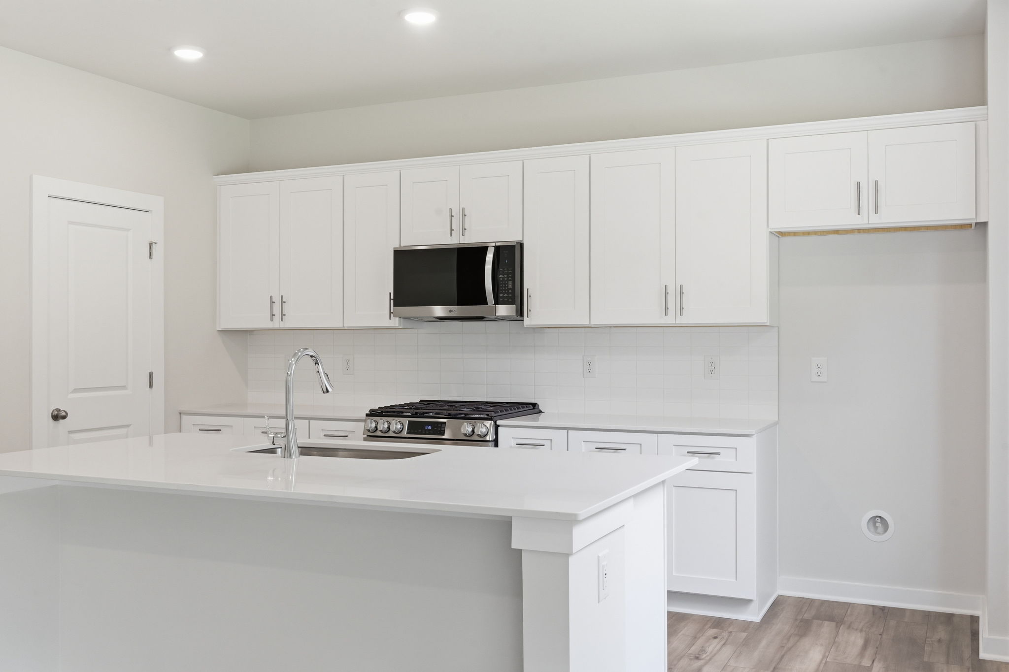 A kitchen with white cabinets.