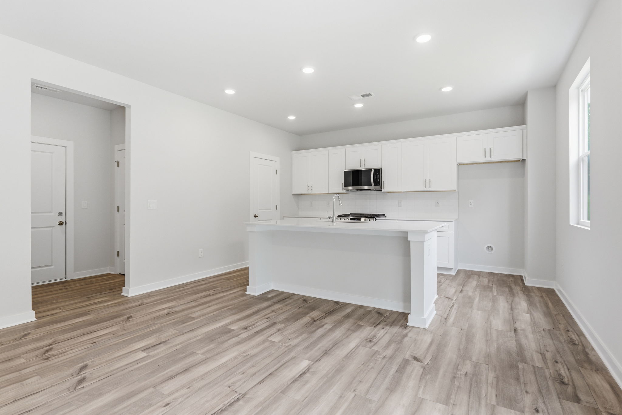 A kitchen with white cabinets.