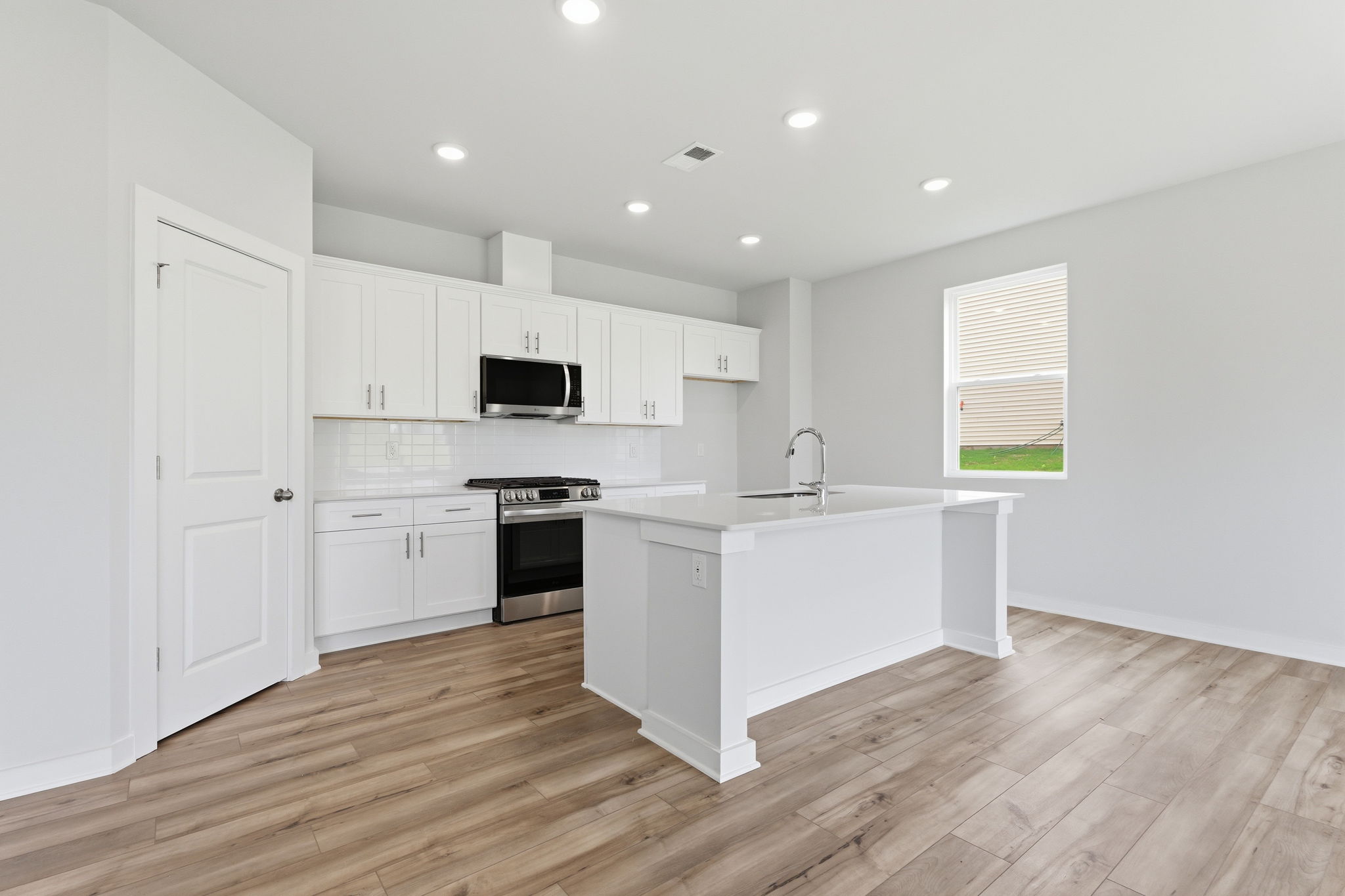 A kitchen with white cabinets.