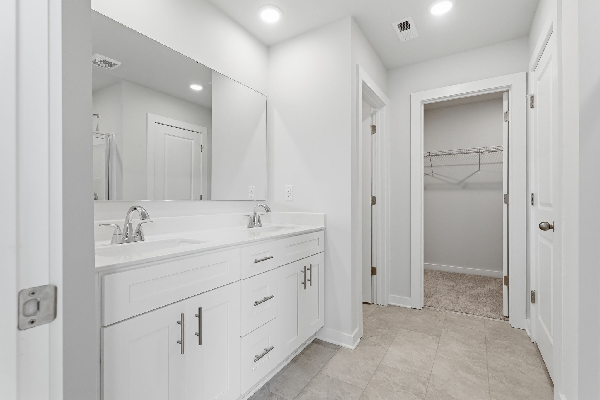 A bathroom with white cabinets.