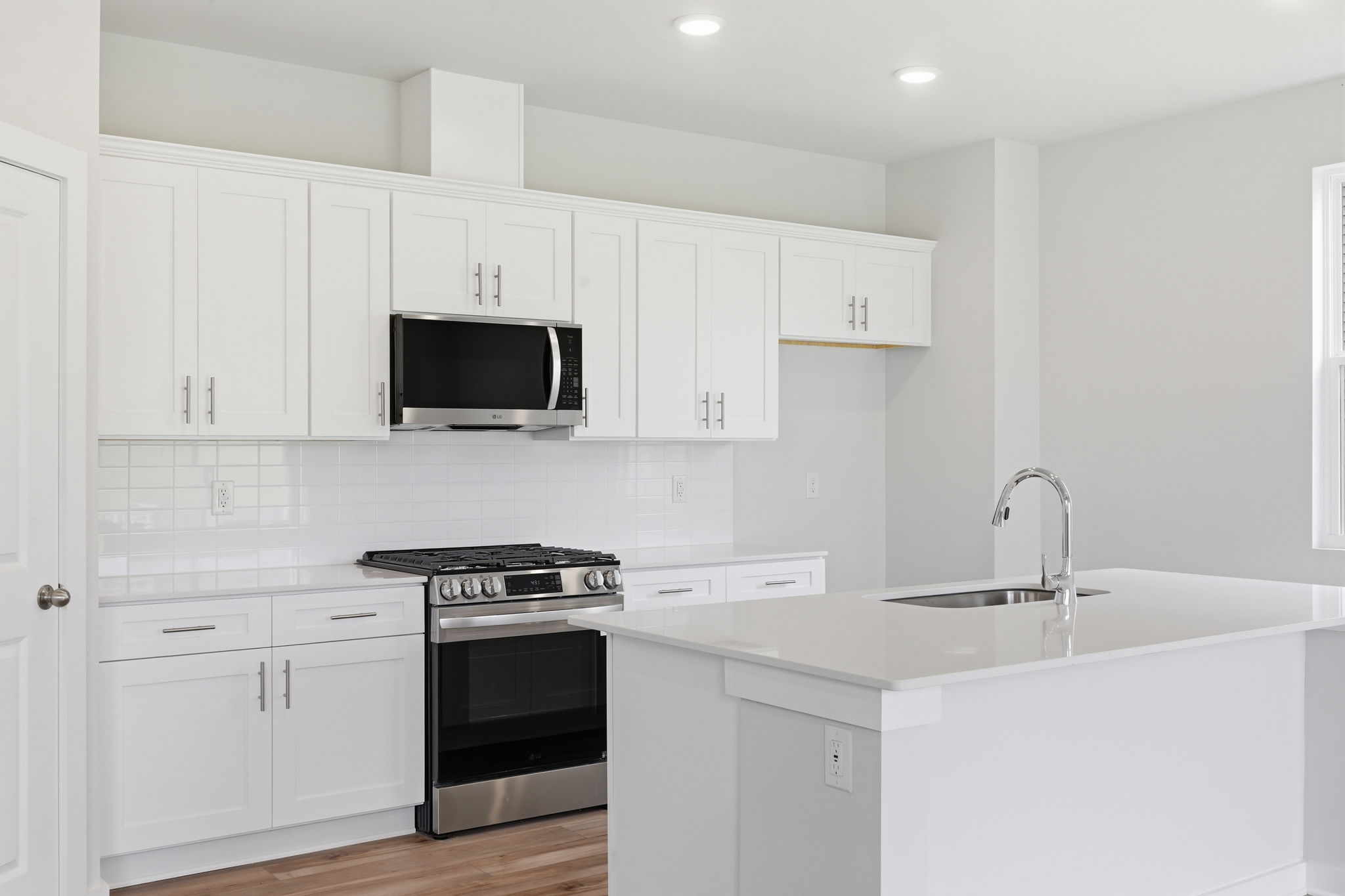 A kitchen with white cabinets.