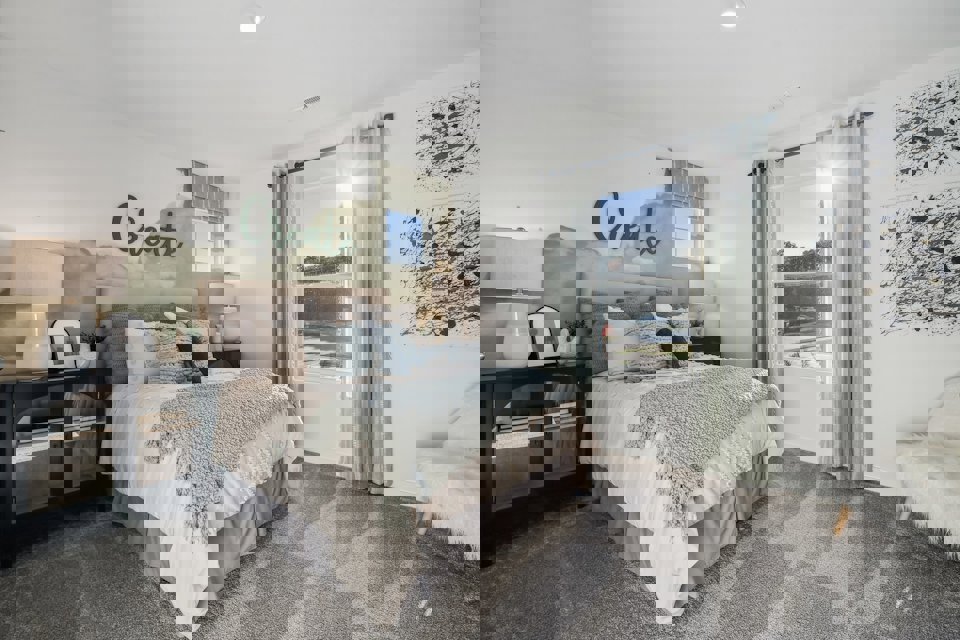 A bedroom with a large window.