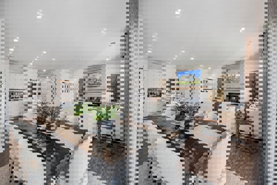 A living room with a large table and chairs.