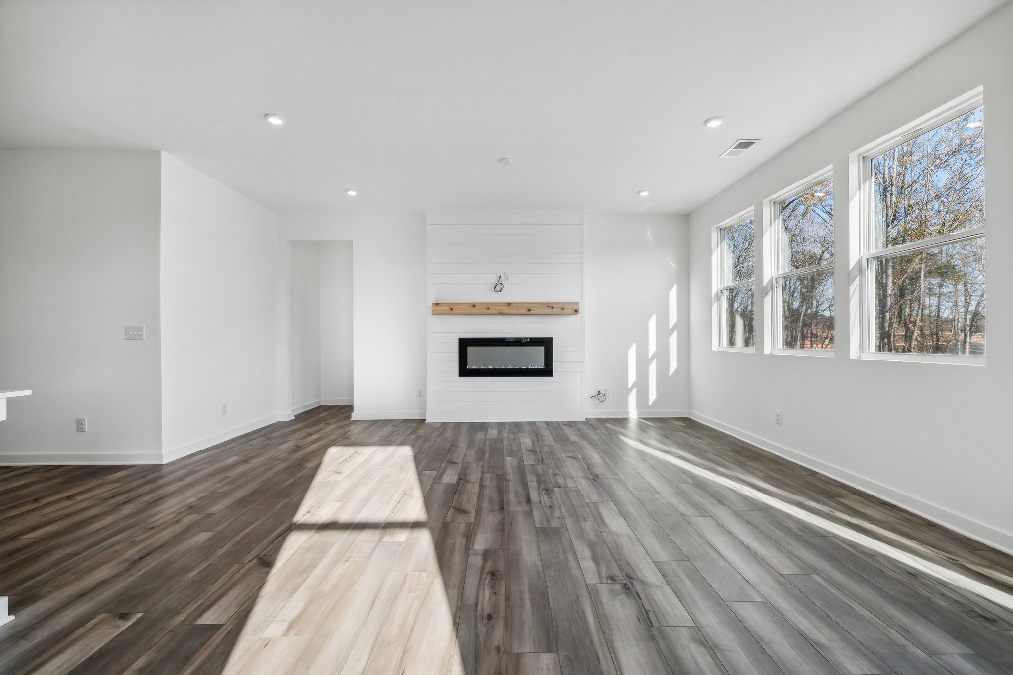 A room with a wood floor and a fireplace.