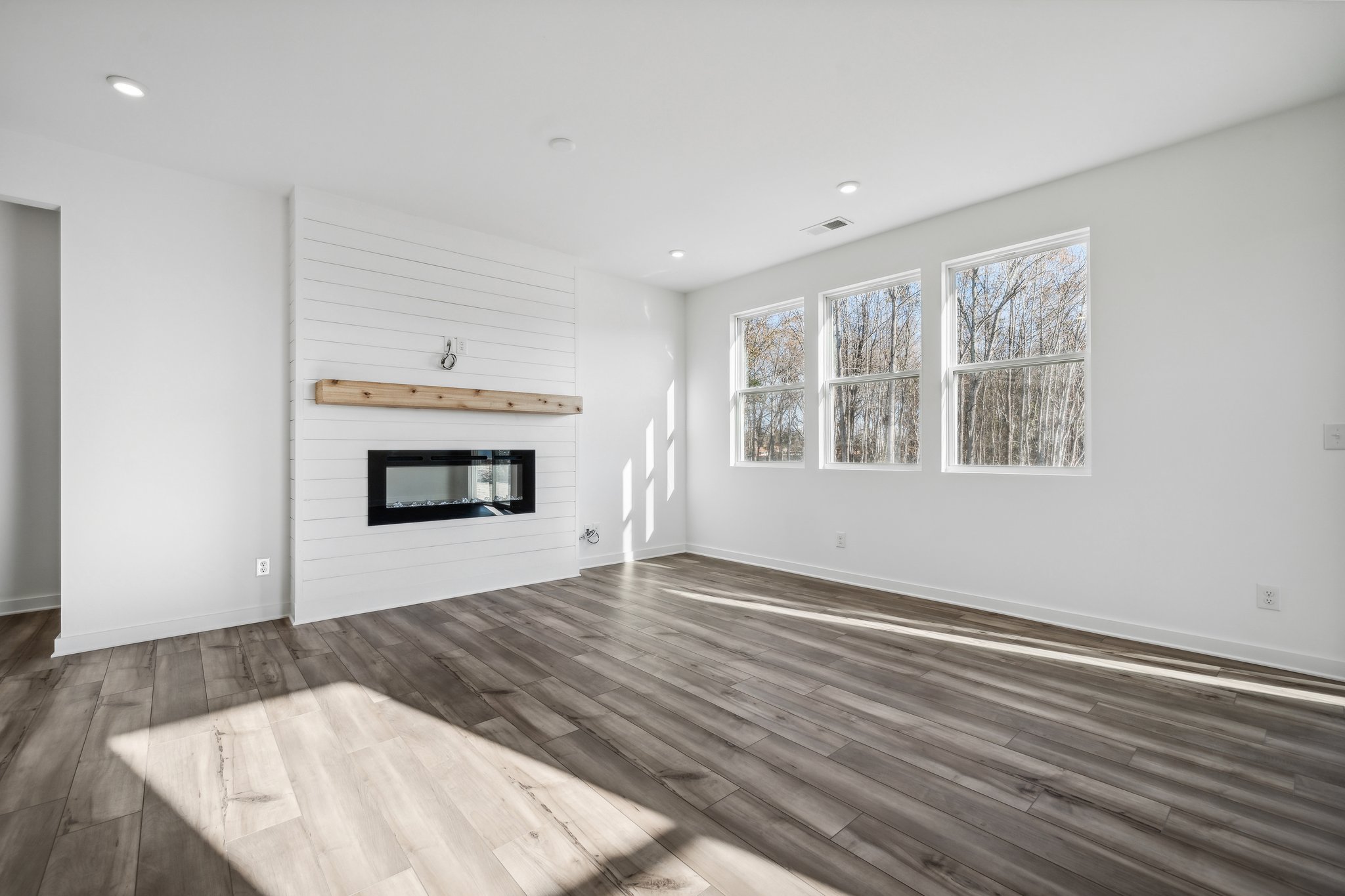 A room with a fireplace and a wood floor.