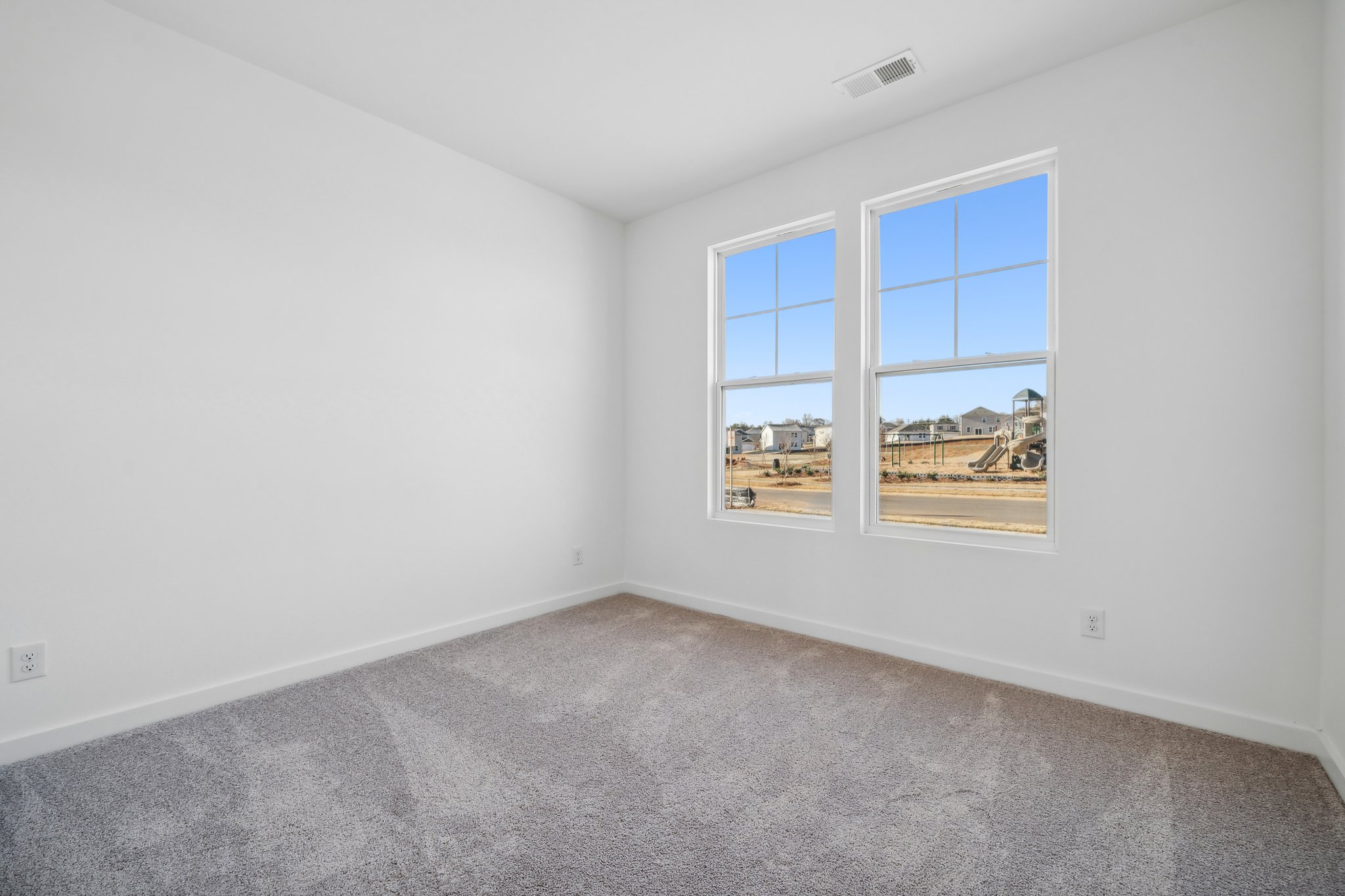 A room with a window and a carpet.