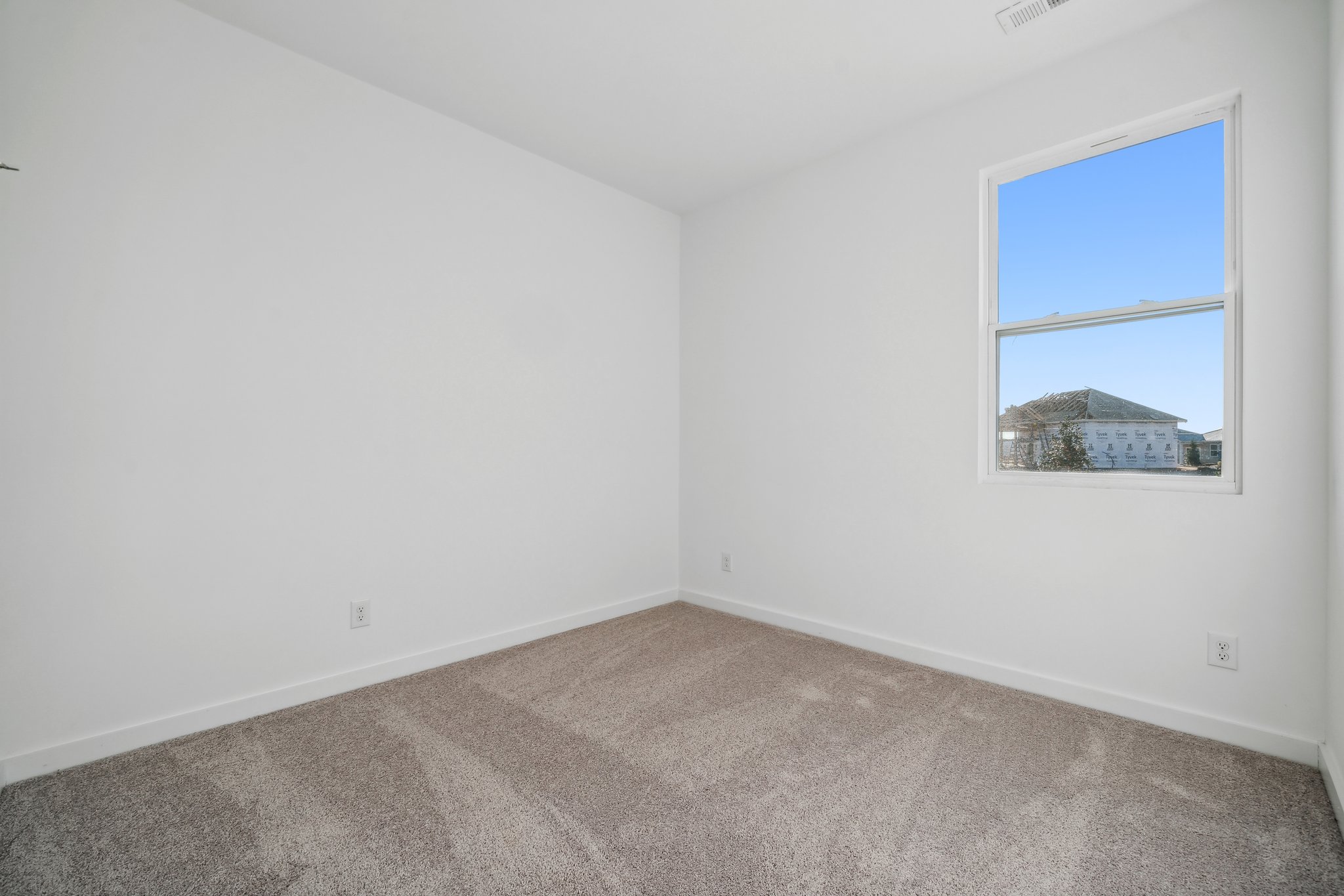 A room with a window and a carpet.