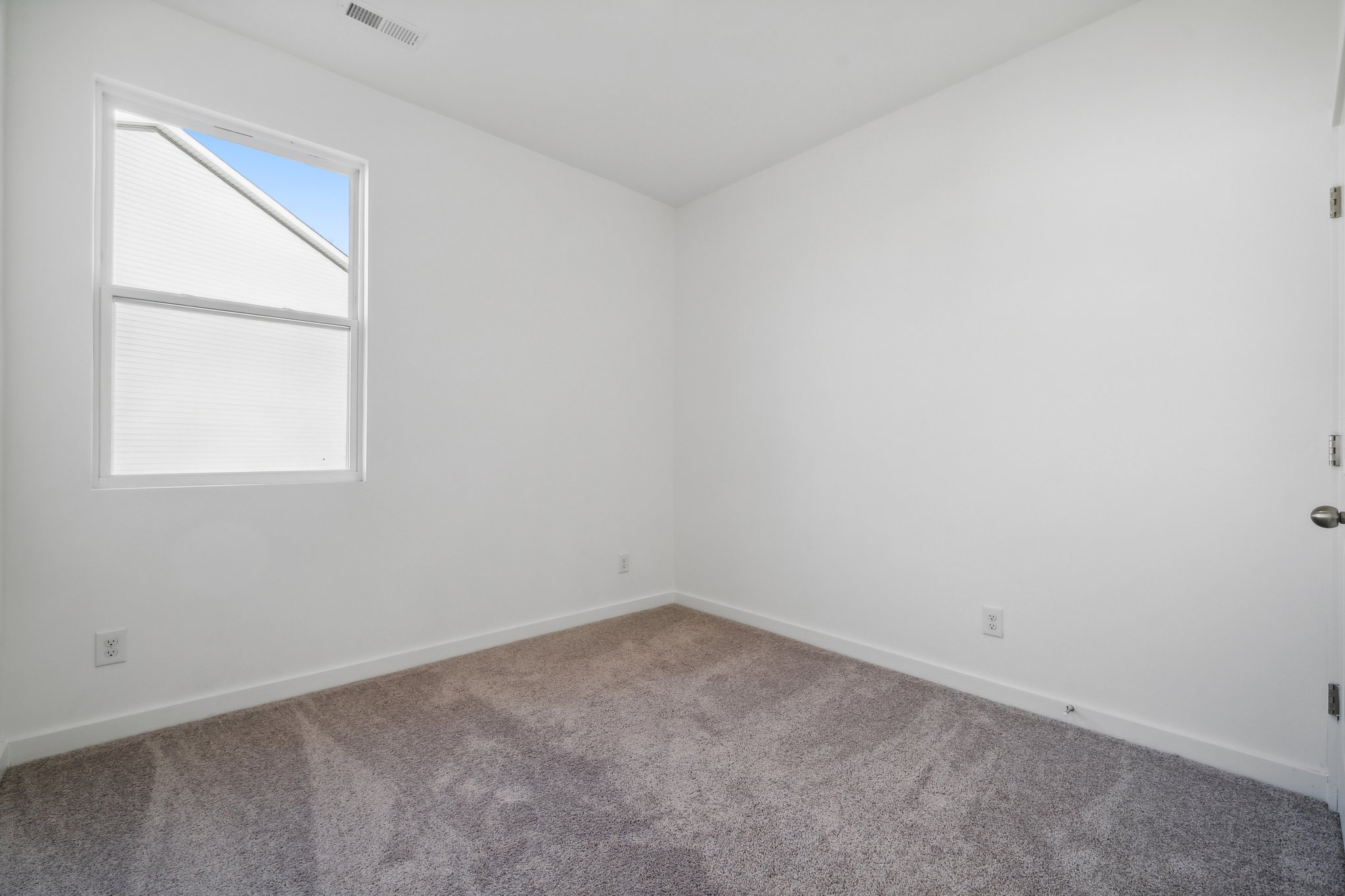 A room with a carpet and a window.