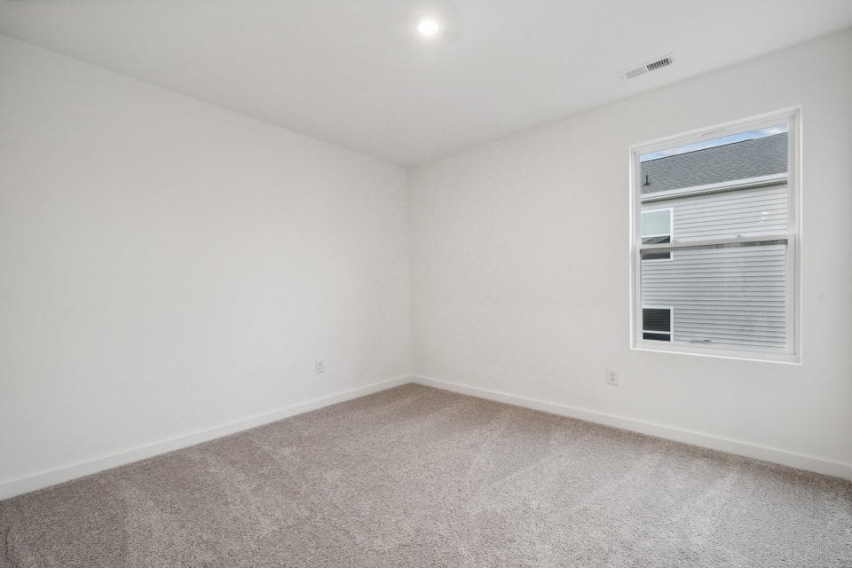 A room with a window and a carpet.
