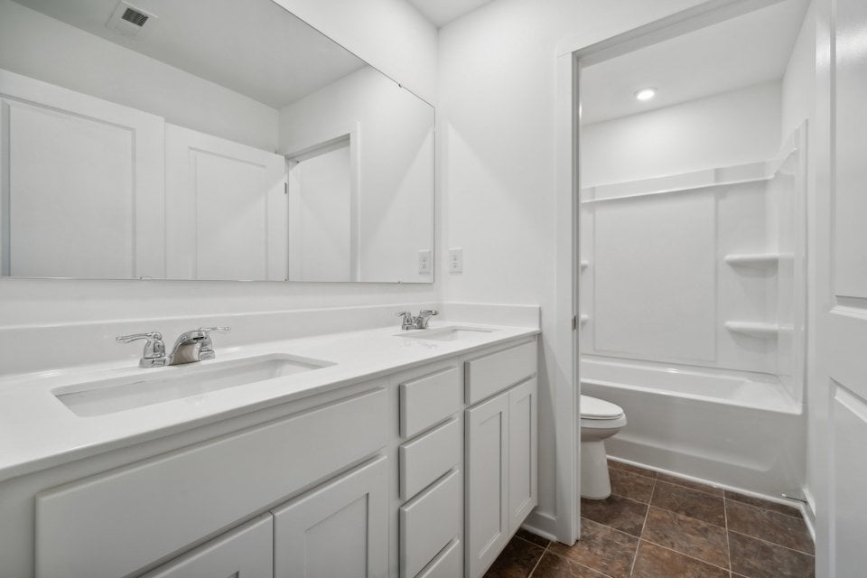 A bathroom with white cabinets.