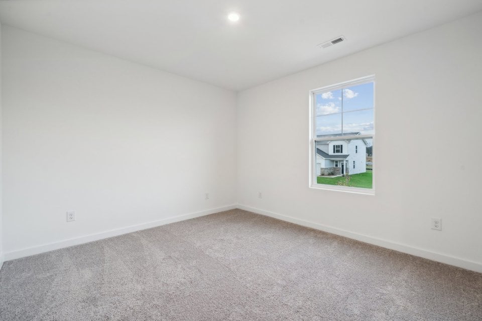 A room with a window and a carpet.