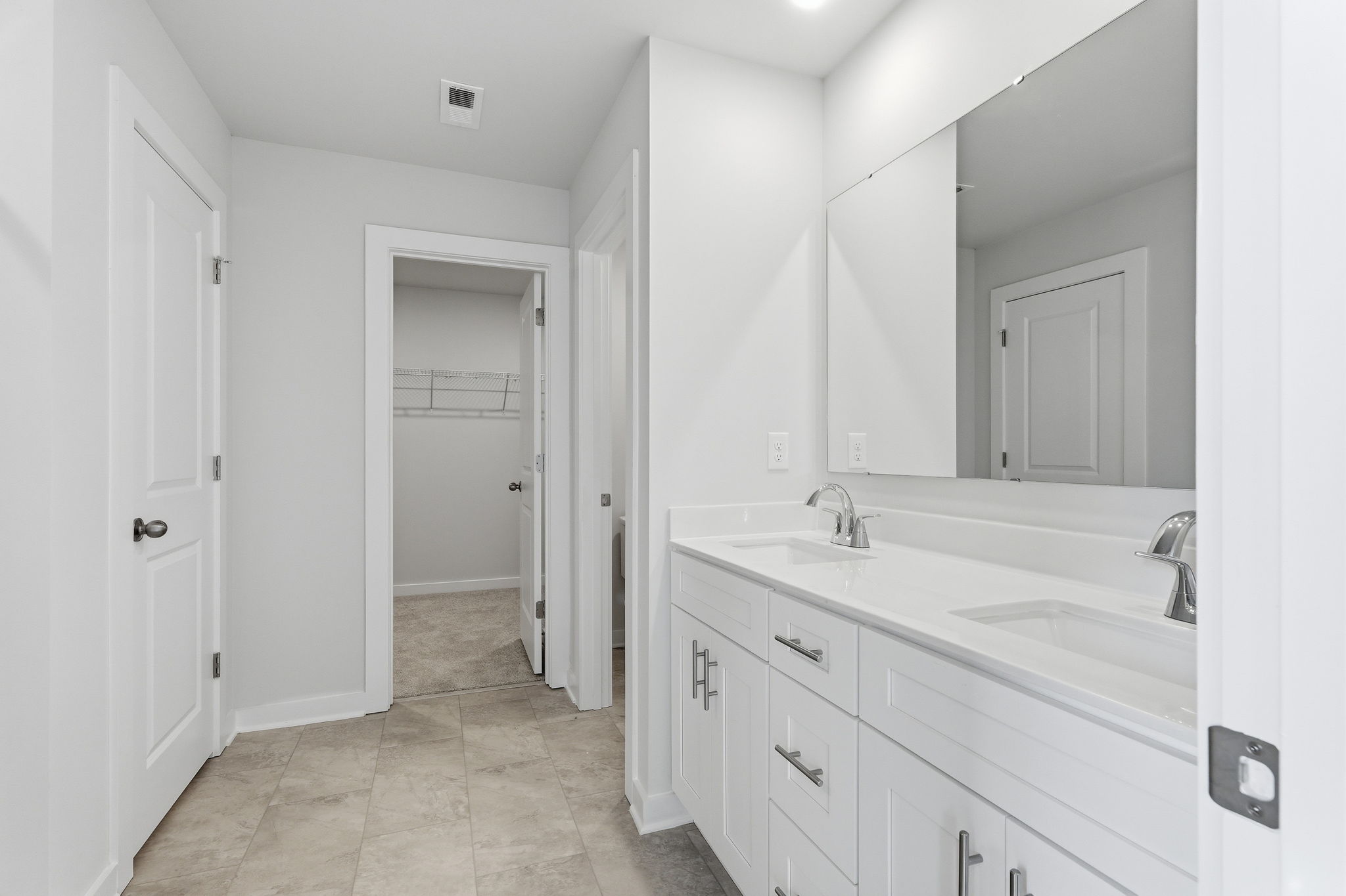 A bathroom with white cabinets.
