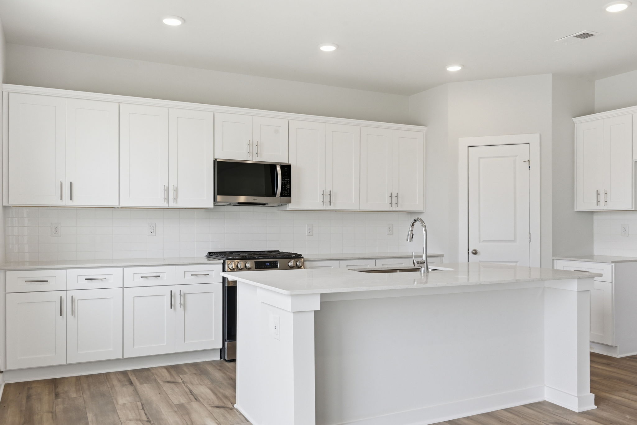 A kitchen with white cabinets.