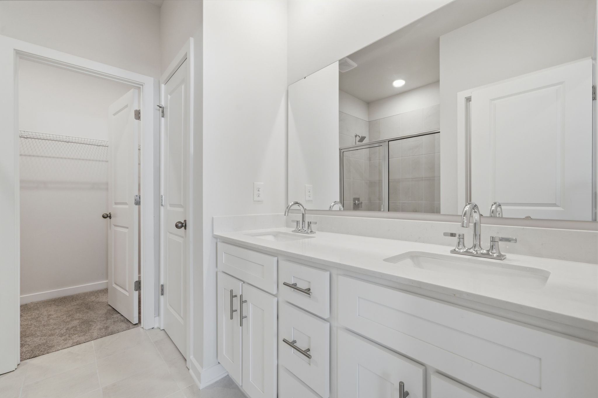 A bathroom with white cabinets.