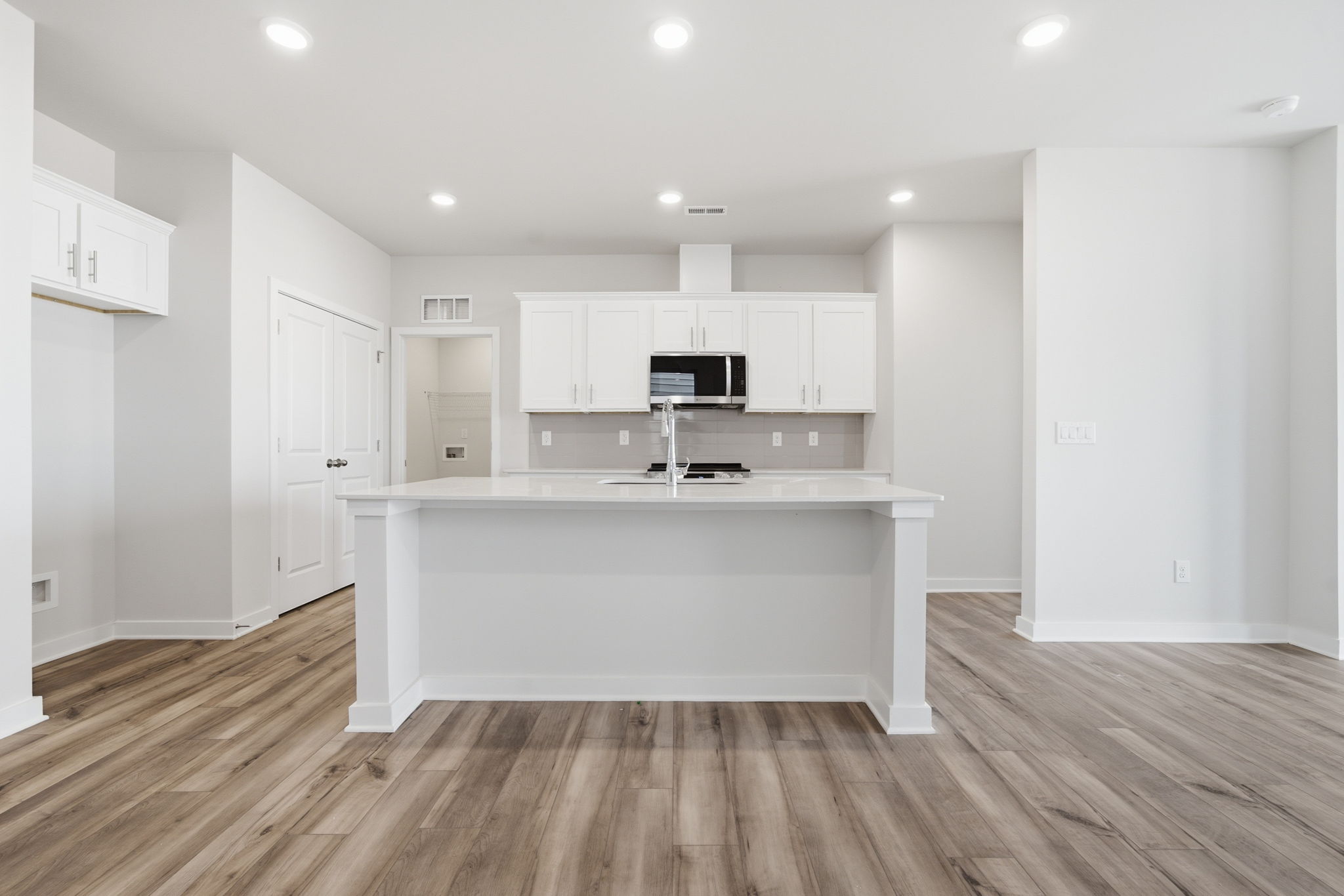 A kitchen with white cabinets.