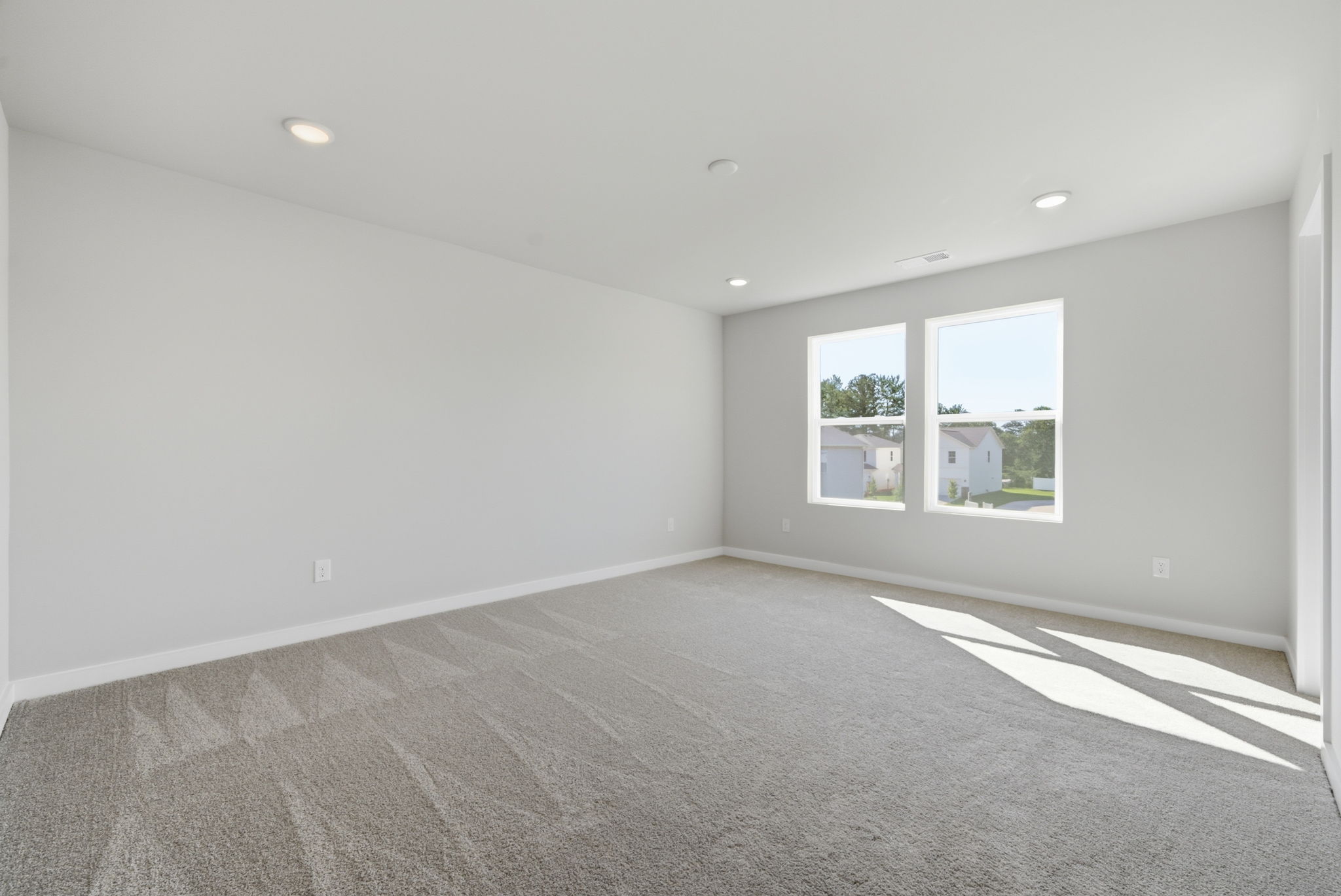 A room with a carpet and windows.