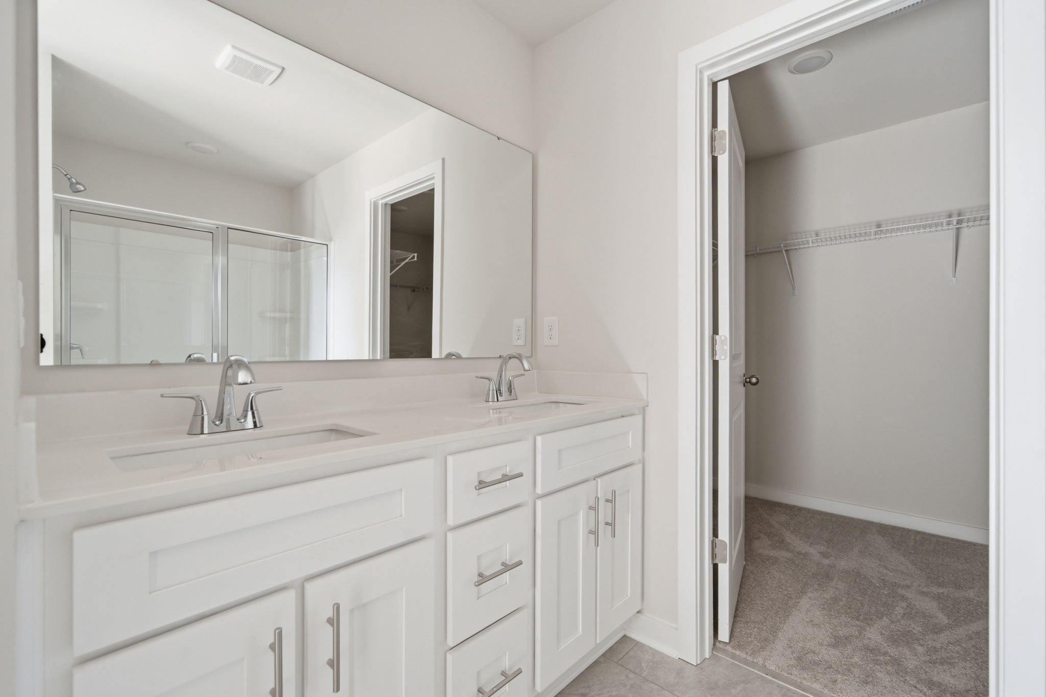 A bathroom with white cabinets.