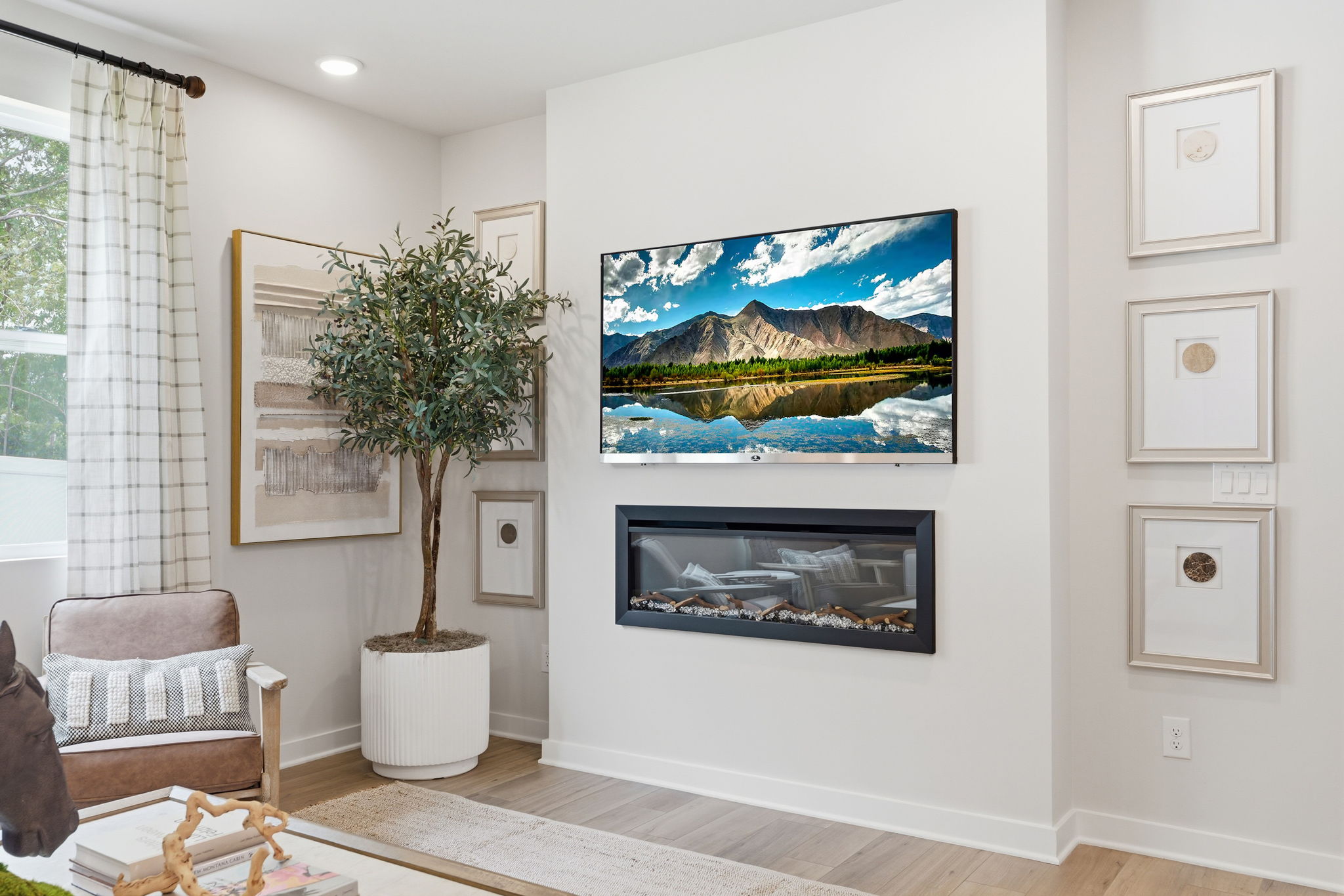 A room with a tree and a painting on the wall.