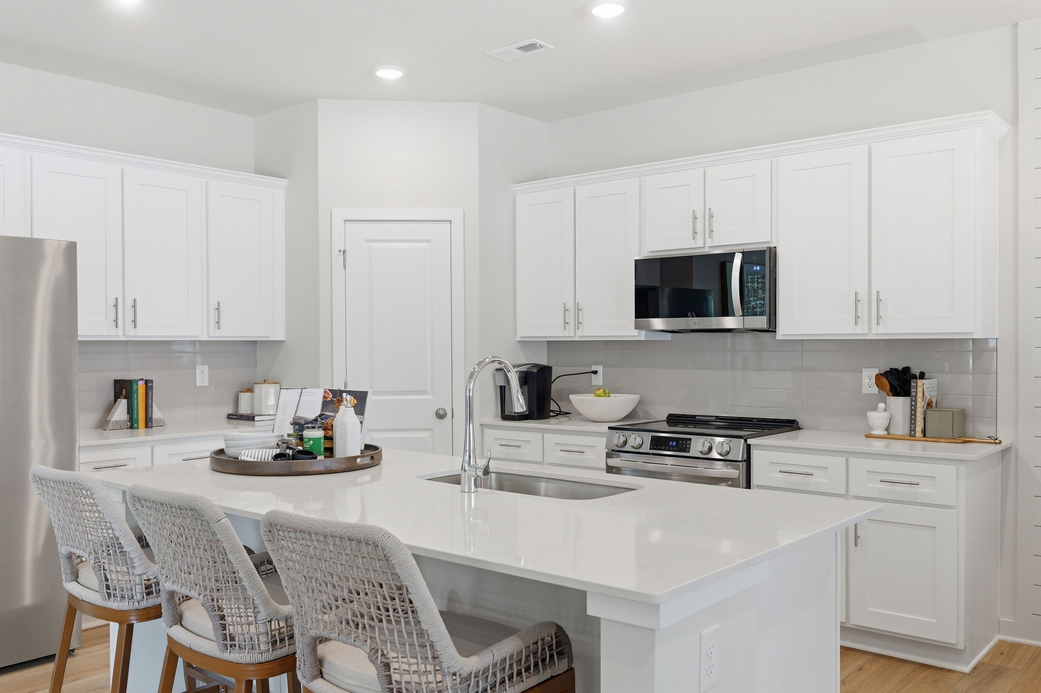 A kitchen with white cabinets.