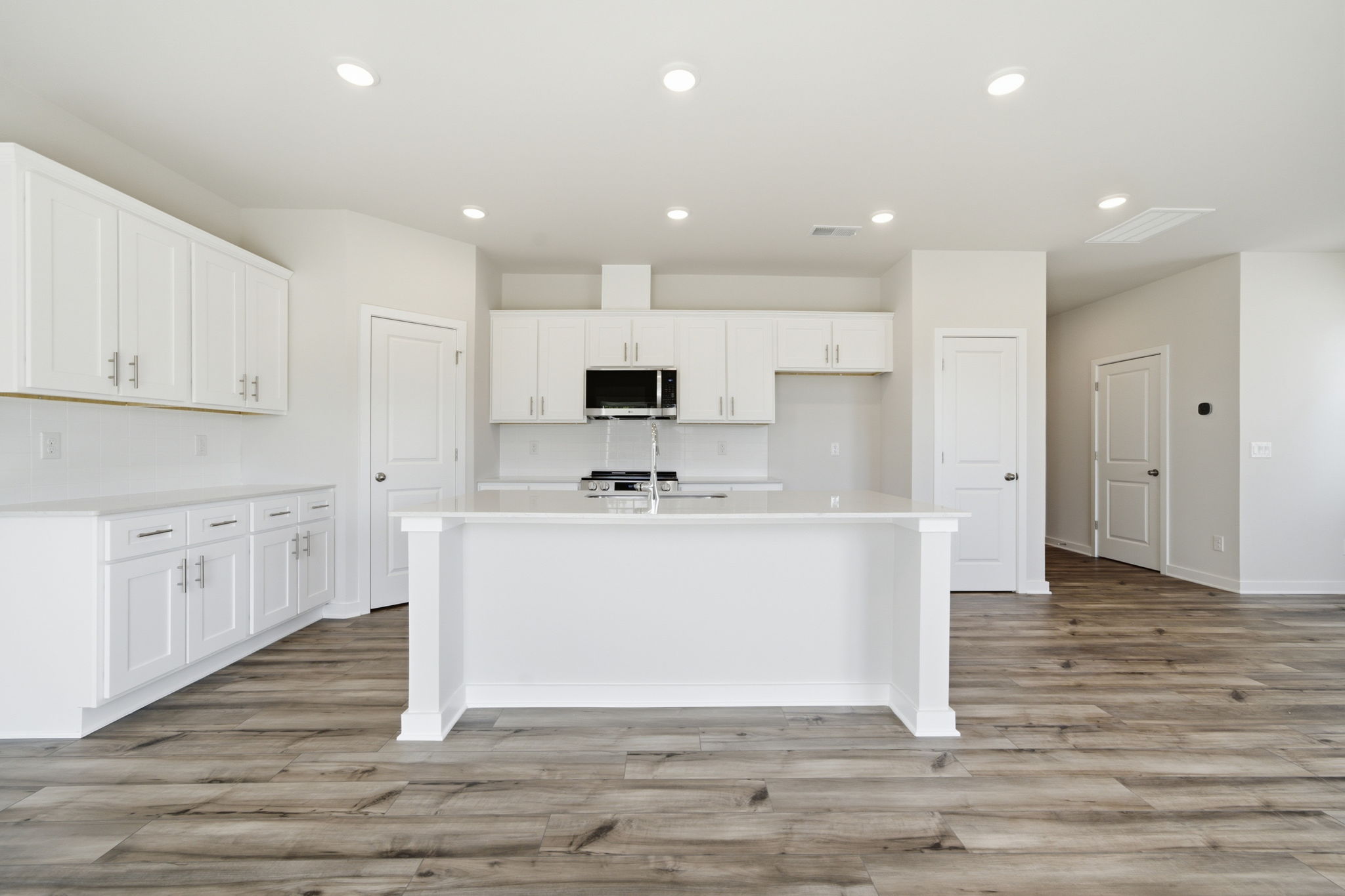 A kitchen with white cabinets.
