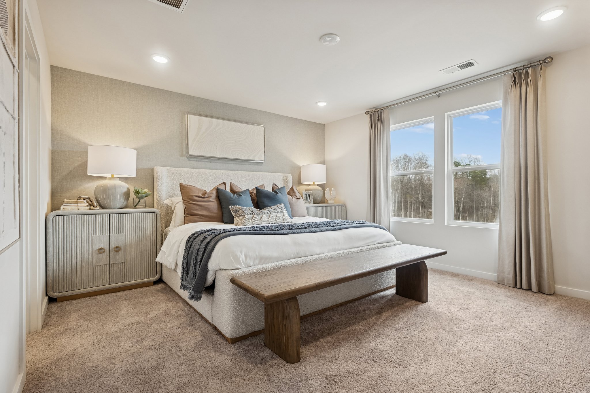 A bedroom with a bed and a bench.
