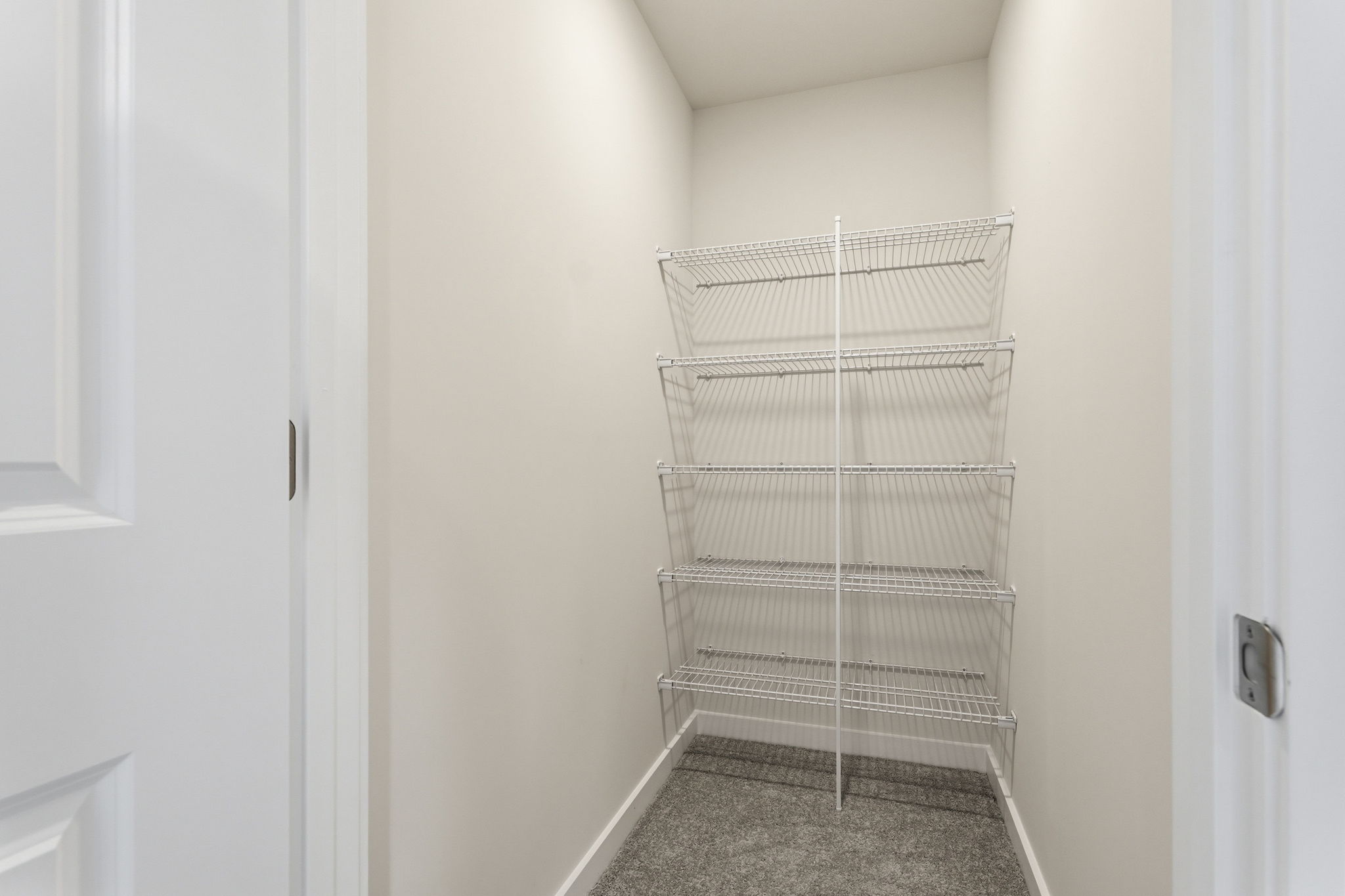 A white wall with a metal rack.