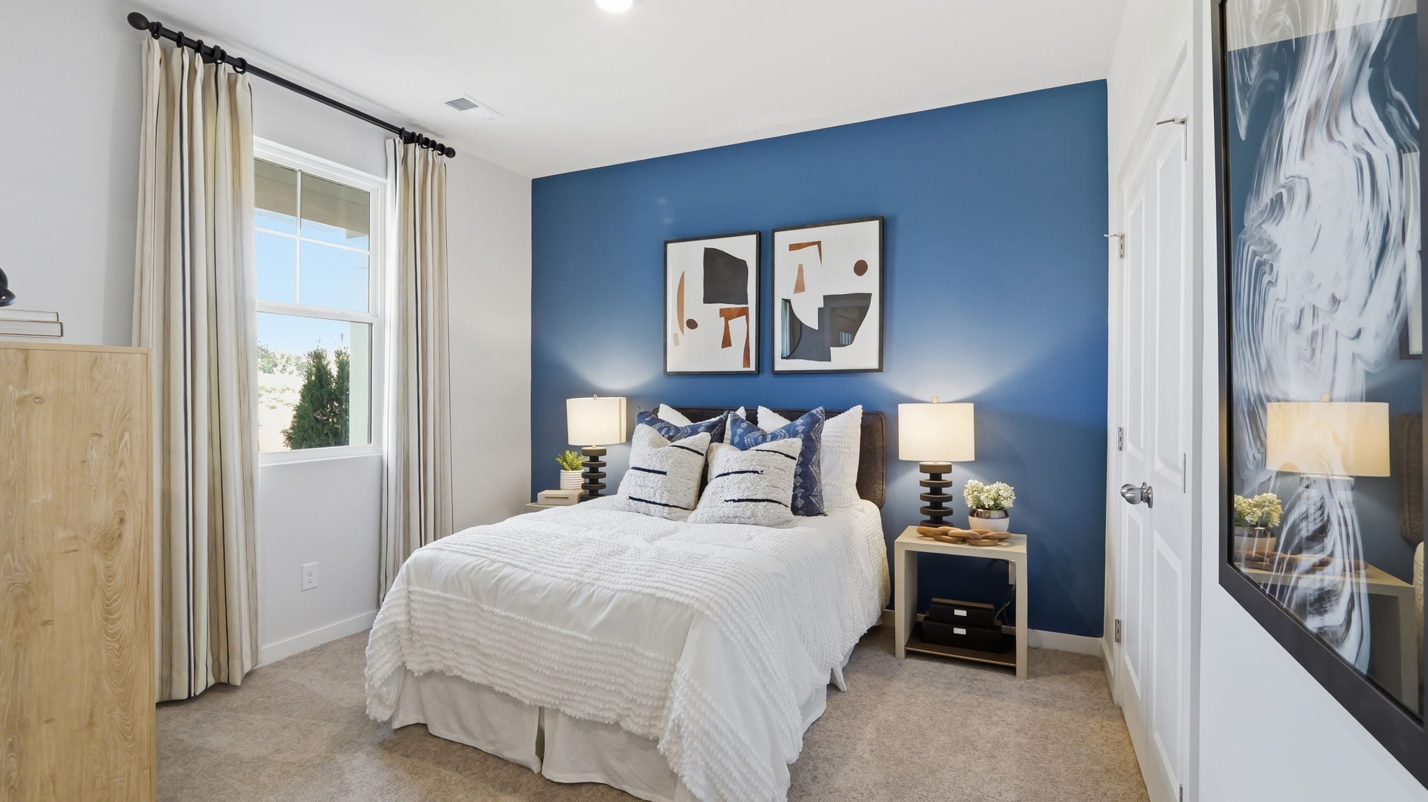 A bedroom with a bed and a lamp.