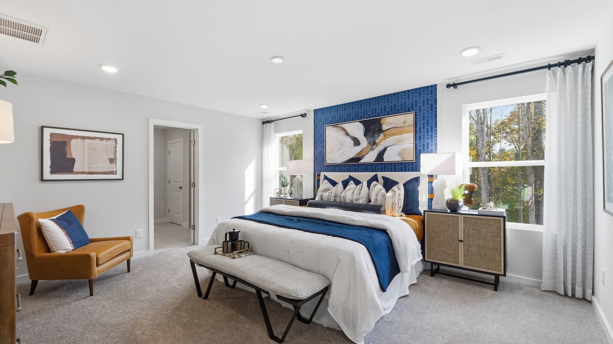 A bedroom with a bed and a chair.