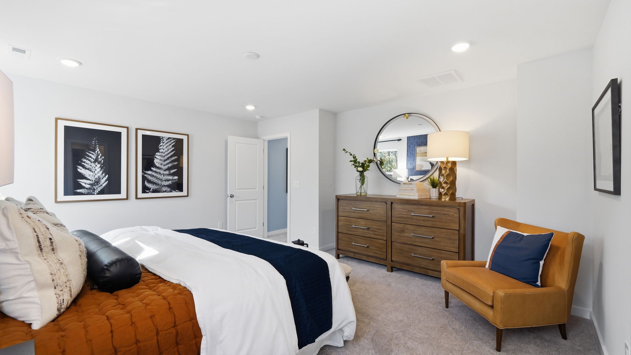 A bedroom with a bed and a chair.