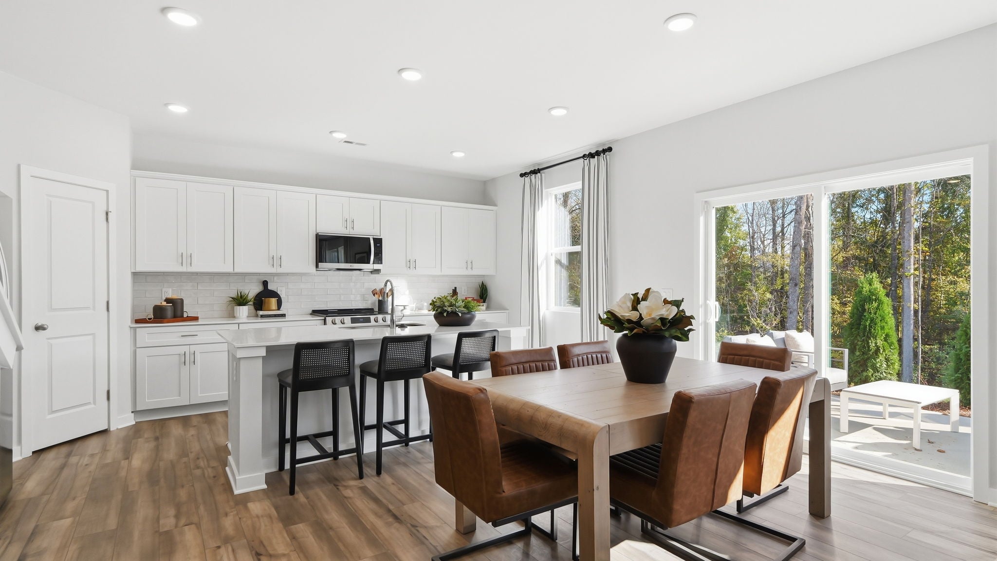 A kitchen with a dining table and chairs.