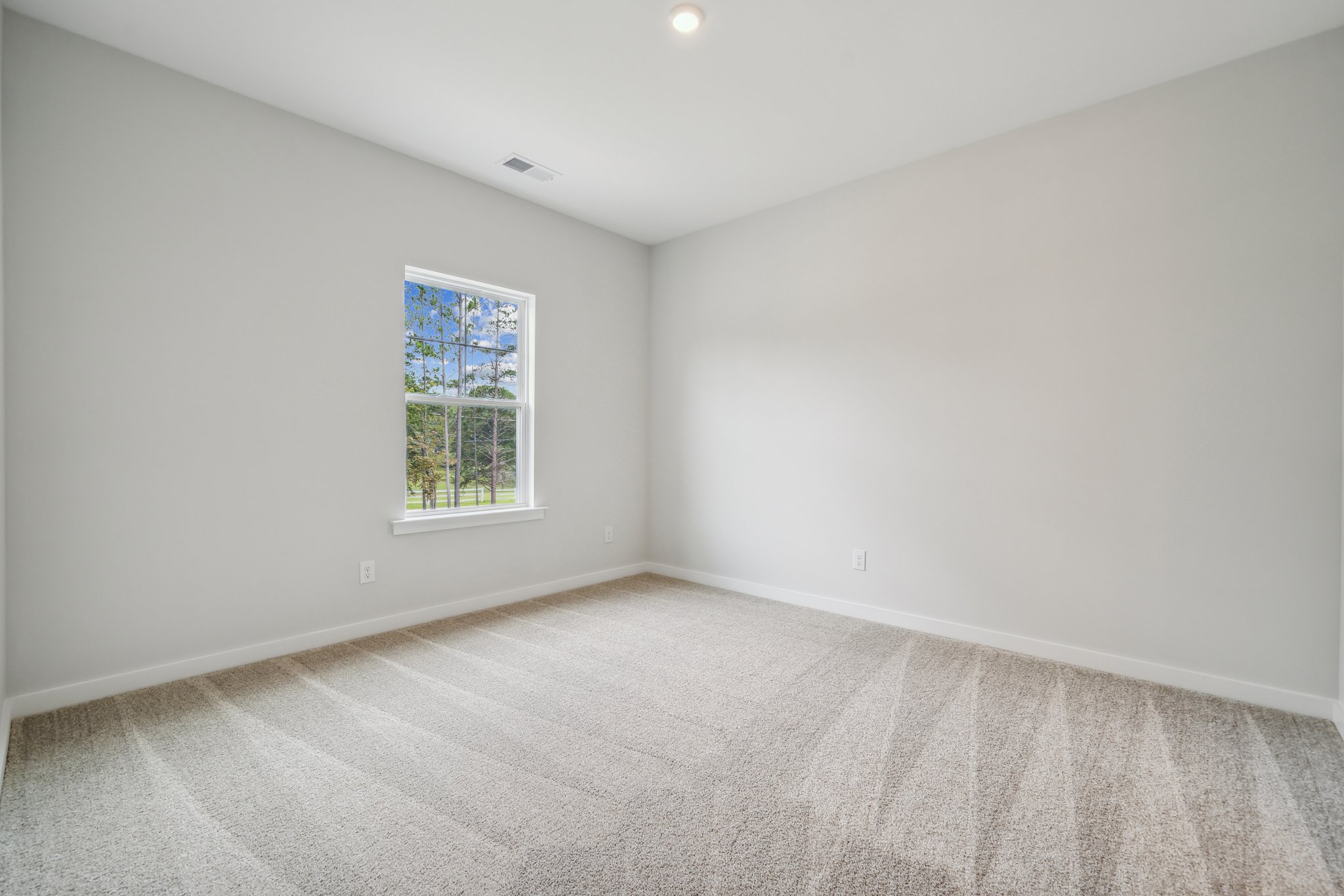 A room with a window and carpet.