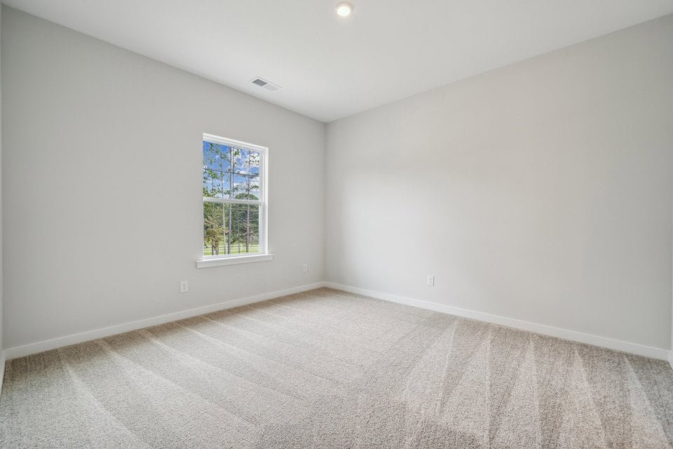 A room with a window and carpet.