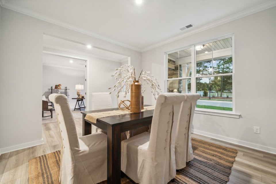 A dining room with a table and chairs.