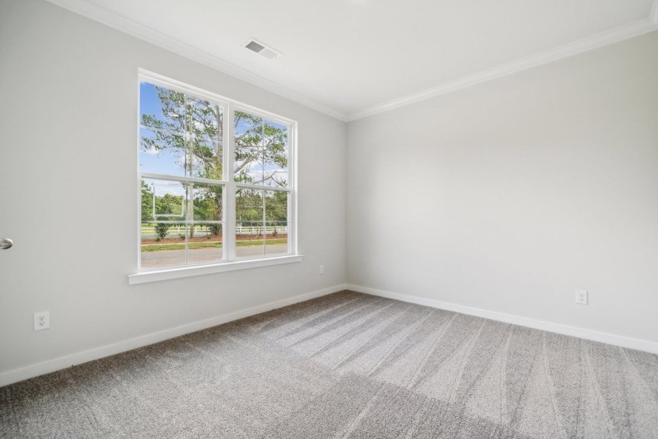 A room with a window and a white wall.