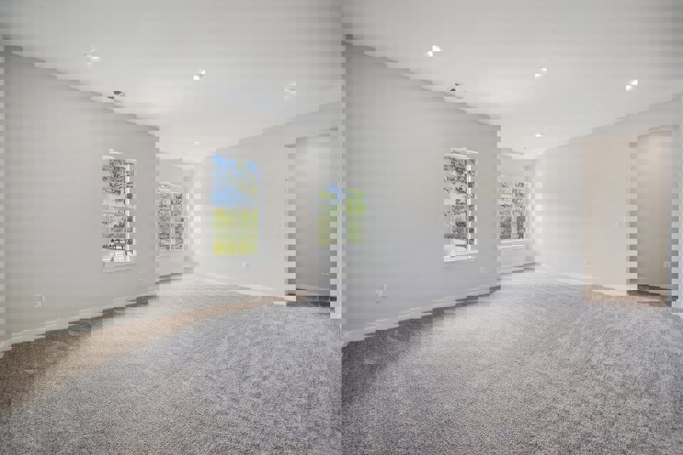 A room with a carpet and a window.