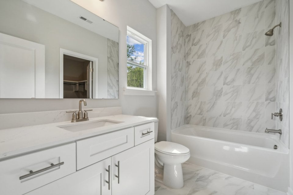 A bathroom with a tub sink and toilet.